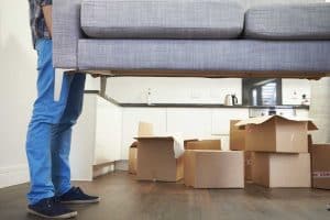 man holding up a couch during moving 300x200 - How to Choose a Moving Company