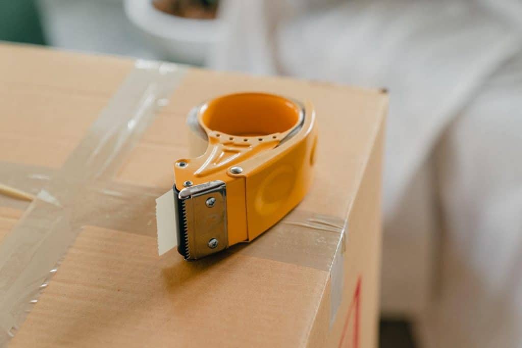 Packing tape gun on a cardboard box.