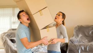 young couple with falling stack of boxes